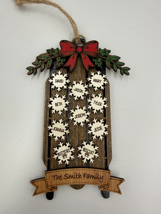 Personalized family sled ornament showing layered wood construction and name snowflakes