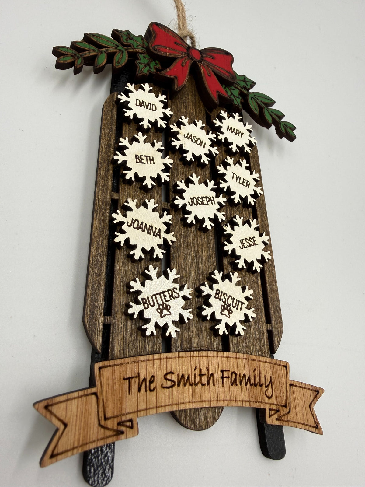 Angled view of personalized wooden family sled Christmas ornament